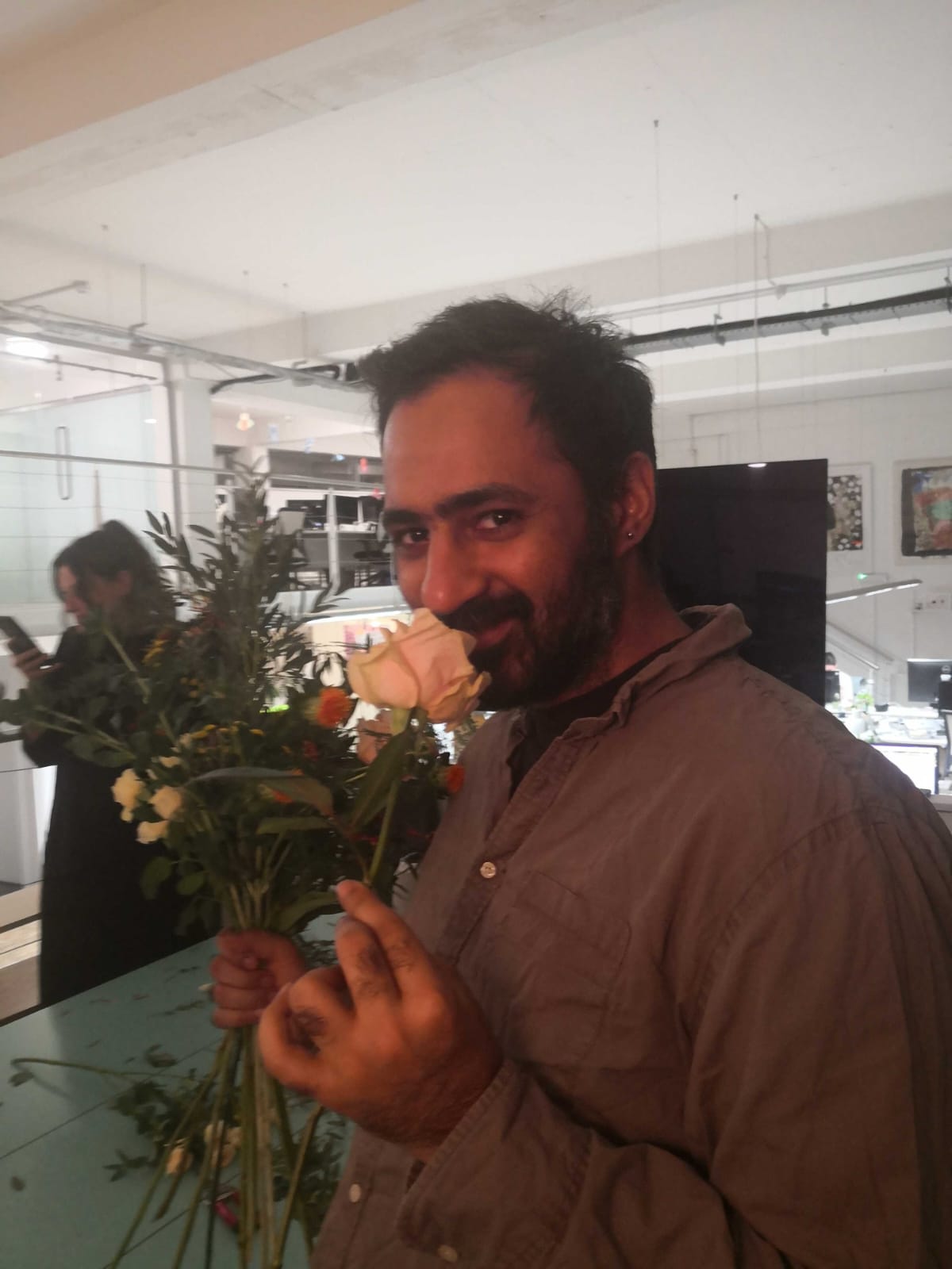 Satyn arranging a bouquet with a rose in the studio